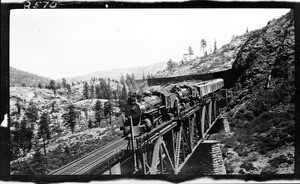 Southern Pacific Railroad train coming out of snow sheds in the mountains near Cisco, ca.1909