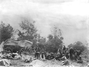 Portrait of cowboys eating around the chuck wagon, 1898