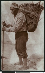 Indian male carrying a basket on his back, ca.1900