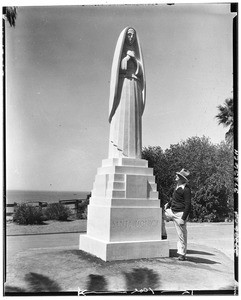 Man standing near a statue of Santa Monica in Santa Monica