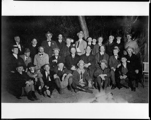 Group portrait of members of the Sunset Club posing in front of a campfire, ca.1910