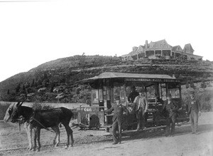 Portrait of men posed around a mule-drawn streetcar at the corner of Downey Avenue and Pritchard Avenue, March 1889