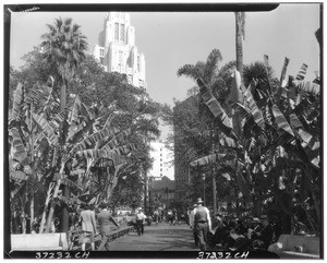 People walking through Pershing Square, showing the Title Guarantee and Trust Company building