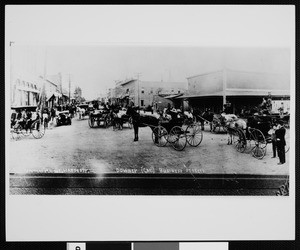 A buisness street in Downey crowded with early cars, horses and buggies, 1911