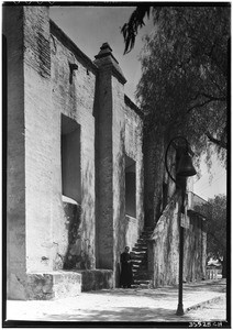 Exterior view of the San Fernando Mission, showing a priest