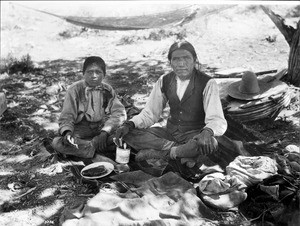 Havasupai Indian boy with his father, Vesna, eating lunch during a walking trip, ca.1899