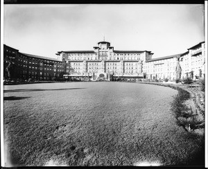 Exterior view of the back of the Huntington Hotel in Pasadena showing a wide expanse of lawn, ca.1914