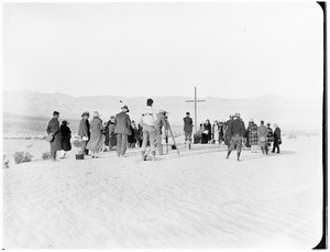 People gathered around a cross for a funeral