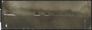 Panoramic view of at least fifteen ships moving as a single row along the ocean water, 1908