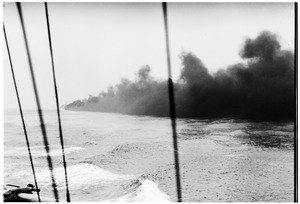 Ship setting a smokescreen on the ocean