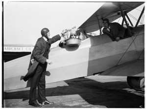 Aviator holding a fish over a steaming pot of water