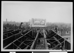 Construction of a bridge, showing men working on structure