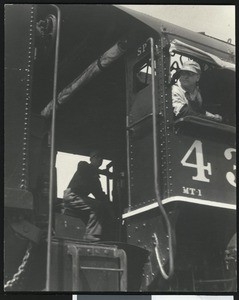 Two men operating a locomotive engine, ca.1920