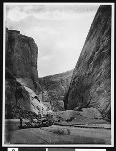 Guiding a small boat through the narrows of the Colorado River at Lee's Ferry in Marble Canyon, Grand Canyon, 1900-1930