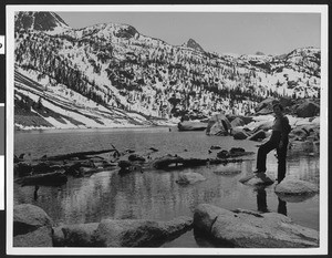 Hiker standing over Lake Sabrina 17 miles back of Bishop with the High Sierras in the background