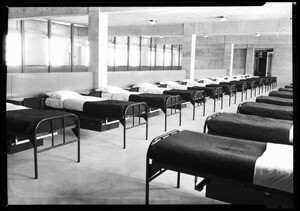 Interior view of a hospital(?) showing rows of beds