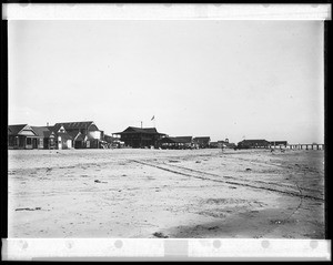 View of Newport Beach, showing commercial buildings and a pier, ca.1908