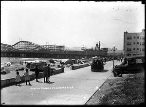 View of the Santa Monica Pleasure Pier showing the roller coaster and a sidewalk car