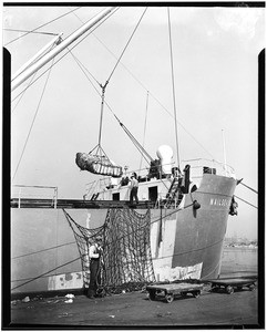 Men loading goods onto a ship