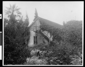 Exterior view of the Palomares adobe, showing the stairs to the attic, ca.1900