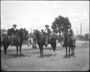 Governor Figueroa and aids dressed up as Spanish caballeros, riding on horses near the Plaza Church during La Fiesta de Los Angeles, ca.1901