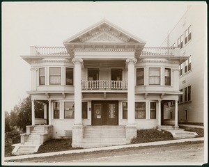 Exterior view of a Colonial Revival-style apartment building at 94042 South Figueroa Street in Los Angeles