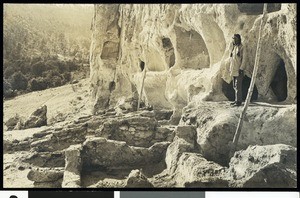 Pueblo Indian standing in the cliff-dwellings ruins at Bandelier National Monument, Los Alamos, New Mexico, 1900-1940