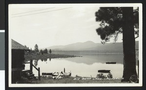 Big Bear Lake with trees, boats, dock and a building, ca.1930