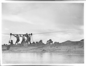 Dr. George Wharton James and five others pulling themselves across the Colorado Chiquito River by cable ferry, ca.1900-1903