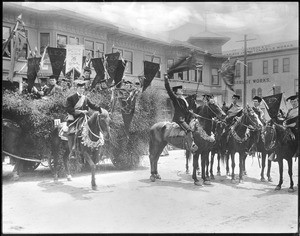 Group of young horsemen and a float at the La Fiesta Parade, Los Angeles, ca.1906