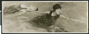 Two women practicing a life-saving drill in a pool, ca.1930