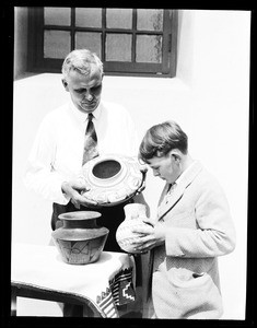 Man and boy looking at Native American pottery at the Pacific Southwest Museum