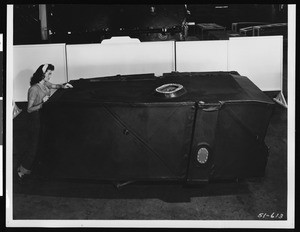 Woman pushing a tank-like object, ca.1945