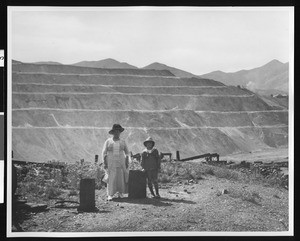 Woman and boy standing in front of a copper mine at Bingham near Salt Lake City, Utah