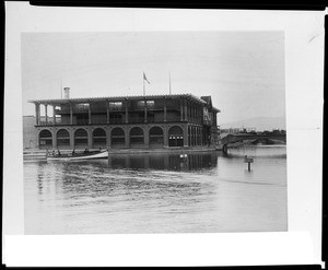 Exterior view of the Venice bath house, showing a passenger boat floating past, ca.1925