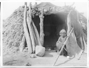 Old Navajo Indian woman of the "Friendly's" sitting at the door of her hogan, ca.1901