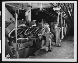 Factory workers placing tires into molds, ca.1930