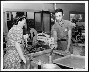 Washing machine repairman at work in a laundromat