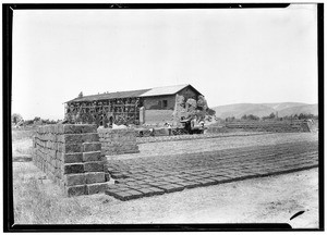 Men renovating the San Fernando Mission, showing adobe bricks in the foreground, July 29, 1927