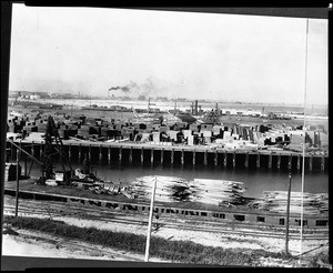 Panorama of the San Pedro Harbor, showing lumber being loaded from ships to freight trains, ca.1913