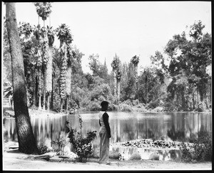 Young boy standing by a lake on Rancho Santa Anita, ca.1920-1940