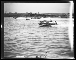 Motorboat racing, showing spectators on jetty in background