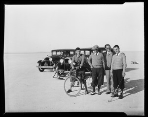 Golfers standing in front of two automobiles