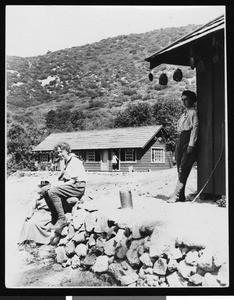 People outside a cabin in the mountains, ca.1930