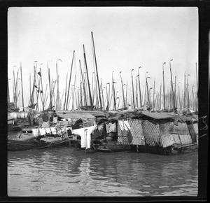 Laundry hanging from a docked river boat in China, ca.1900