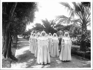 Group of eight Dominican sisters processing in the garden at their convent at Mission San Jose, ca.1906