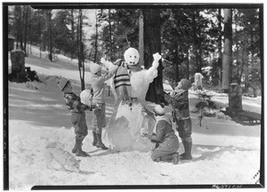 Campers making snowman at a large gathering of people at picnic grounds, Big Pines Recreational Camp