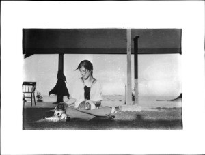 Young girl playing on the ground in front of a patio built as a breezeway on a house in the desert