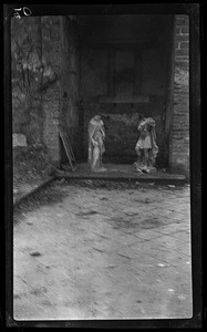 View of two decapitated statues in a damaged building, ca.1916