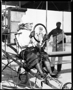 Portrait of a mysterious "woman" aviator, probably Lincoln Beachey in disguise, at the controls of a biplane at the Dominguez Hills Air meet, 1912